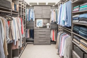 A custom closet system with hanging rods, drawers, shelves, and cabinets